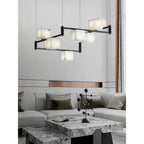 The Clérachic Ostruvye lit above a veined marble coffee table in an open, softly furnished living room.