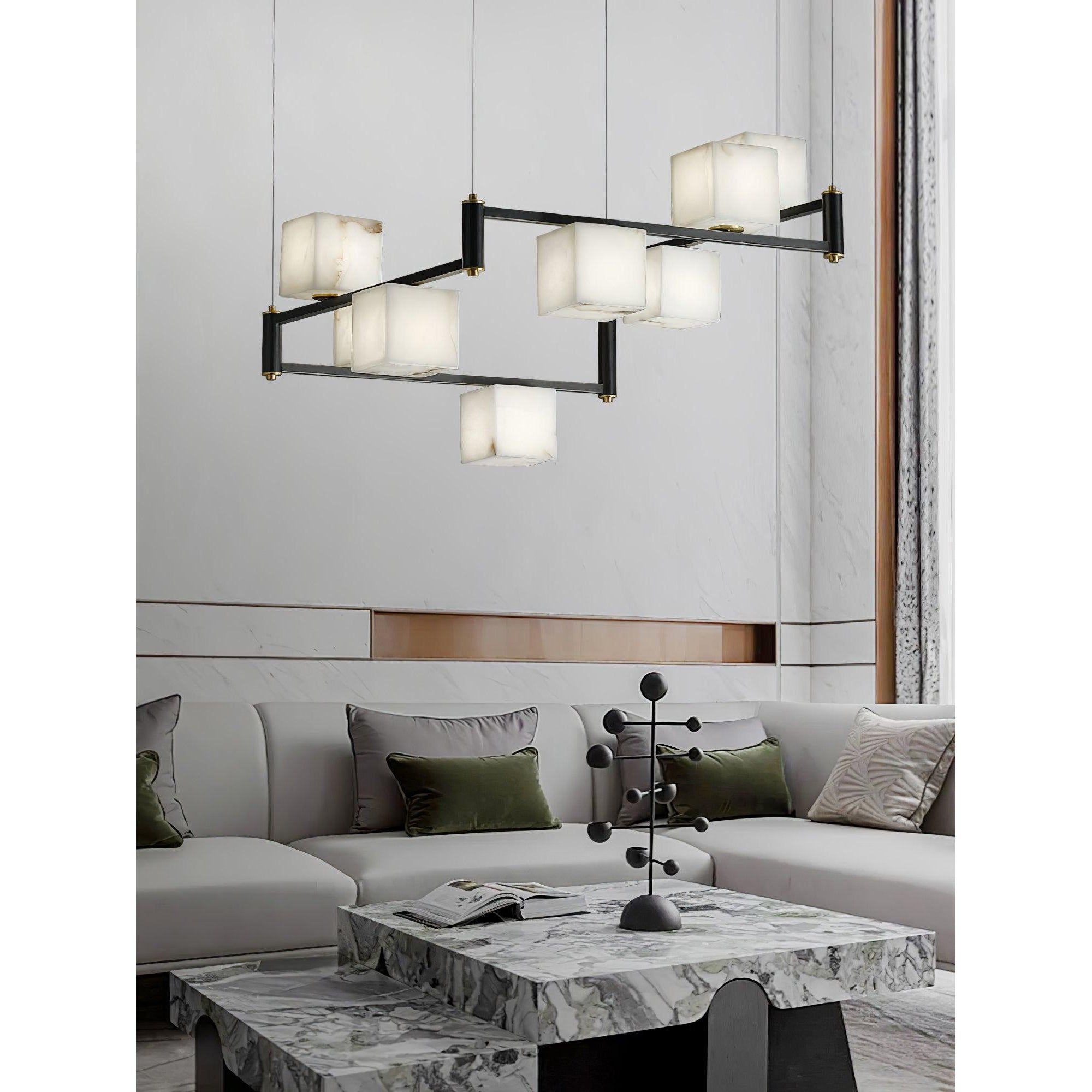 The Clérachic Ostruvye lit above a veined marble coffee table in an open, softly furnished living room.