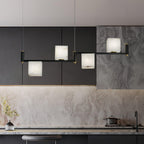 The Clérachic Ostruvye running above a kitchen island, its cubes picked out against dark cabinet fronts.