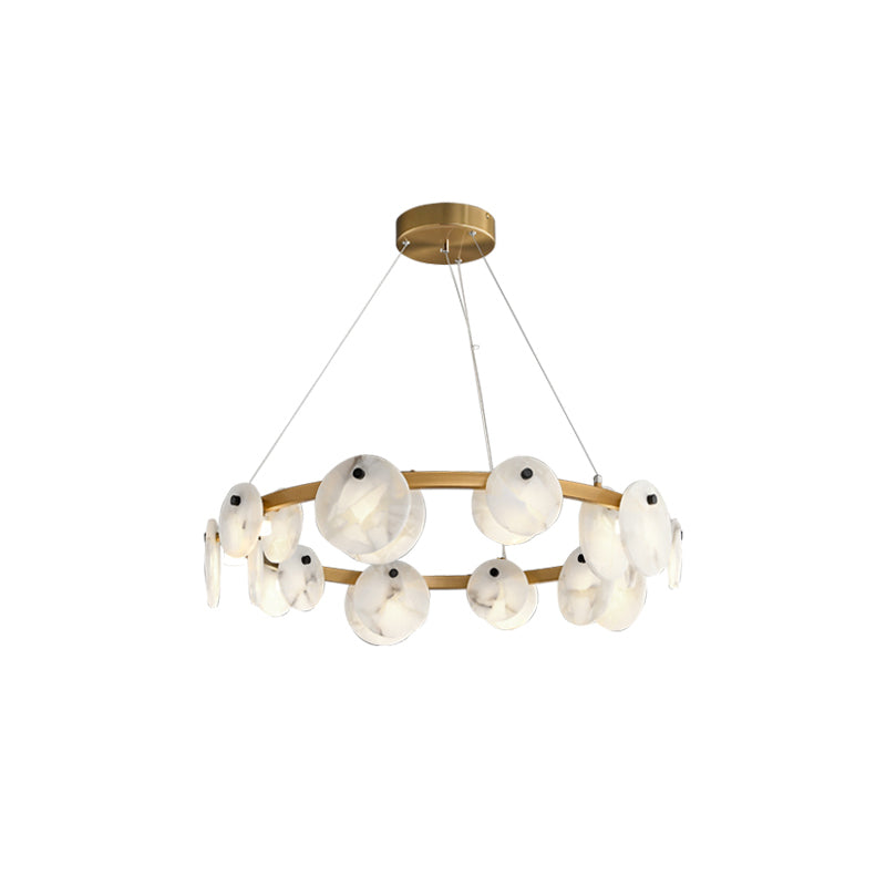The Clérachic chandelier head-on, its wide brushed brass ring lined with pale alabaster discs and lit round shades.