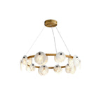 Clérachic chandelier at eye level, alabaster discs alternating with glowing orbs along the gold-toned brass band.