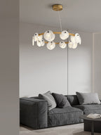 The Clérachic chandelier seen from a doorway, hanging above a deep grey modular sofa in a calm living room.