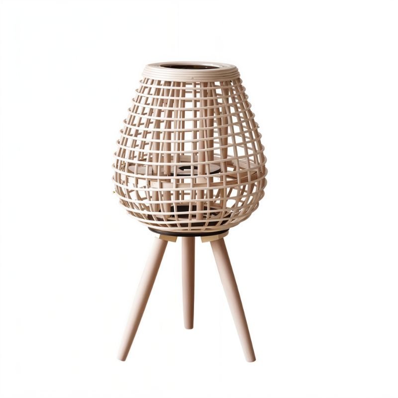 Clérachic compact teardrop lantern in pale woven cane on three short tapered legs, with a candle space inside.