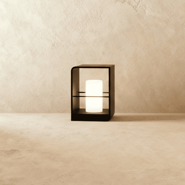 Clérachic small black lantern with a glowing white candle-style cylinder, standing on a pale stone floor against a limewash wall.