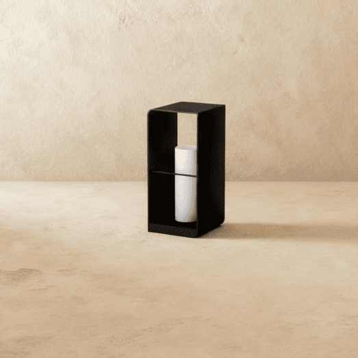 Clérachic medium black lantern with its white candle-style cylinder switched off, standing on a pale floor by a plaster wall.