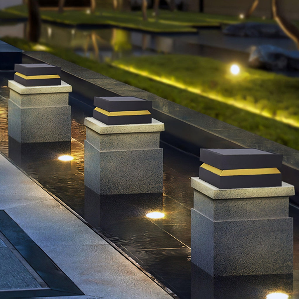 Three Clérachic post lights stepping down a pool edge at night, each casting a warm yellow band.
