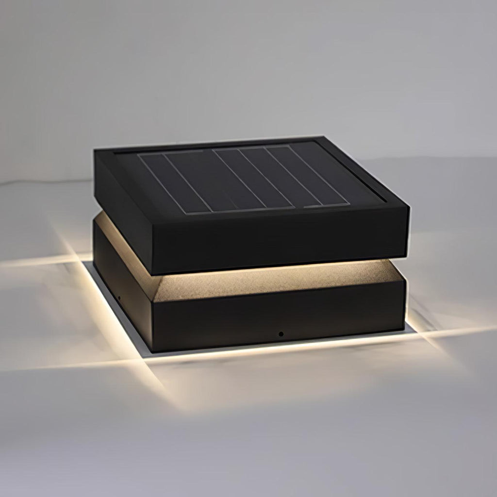 Clérachic square post light with its warm light cast across a pale surface and a solar panel on top.
