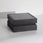 Clérachic square post light unlit on a pale grey surface, showing the ridged solar panel and darker base.