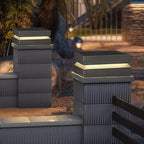 Close on a ribbed pillar topped with a lit Clérachic post light, another pillar behind in the dusk.