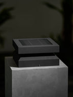 Clérachic post light seen from a low angle on a stone block, its solar lid offset over the base.