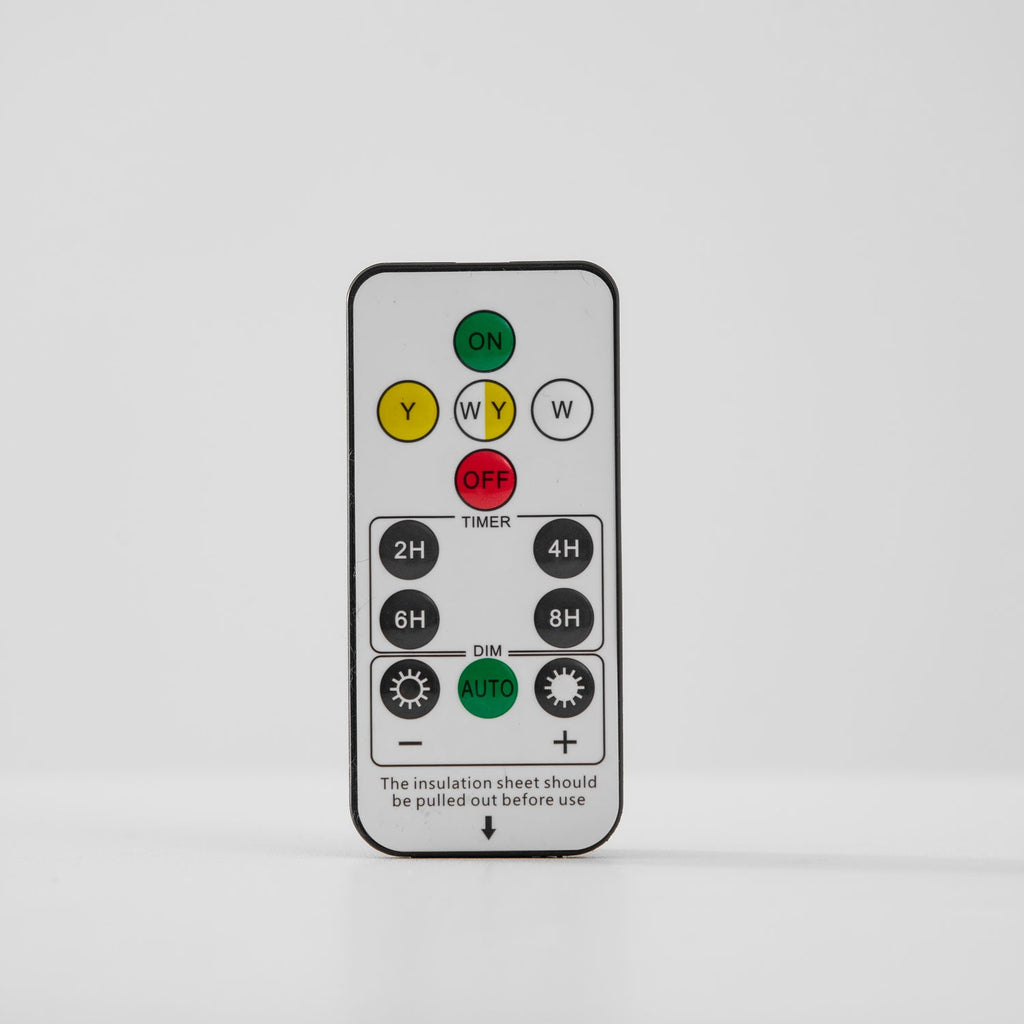 Remote control with on, off, timer and dimming buttons, shown on a pale grey backdrop for this Clérachic light.