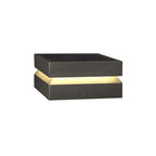Clérachic post light on white with a warm band lit between its solar lid and the dark base.