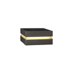 The smallest-looking Clérachic post light on white, with a warm band glowing under its dark lid.