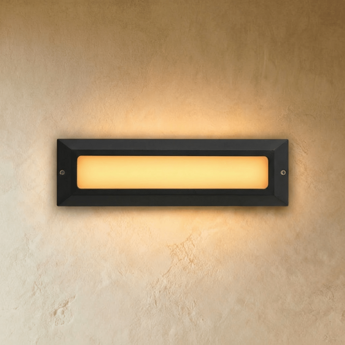 Clérachic large rectangular step light in dark grey with a long frosted panel glowing warm white on a plaster wall.