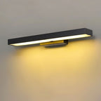 Clérachic long black bar wall light with a warm amber glow on a plain grey wall, seen at an angle with its brass-toned bracket.