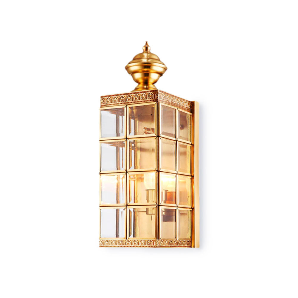 Clérachic brass lantern wall light on white, shown from slightly to the side to show its glass panes and etched brass border.