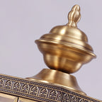 Close view of the turned brass finial and the etched leaf-pattern band on top of this Clérachic wall light.