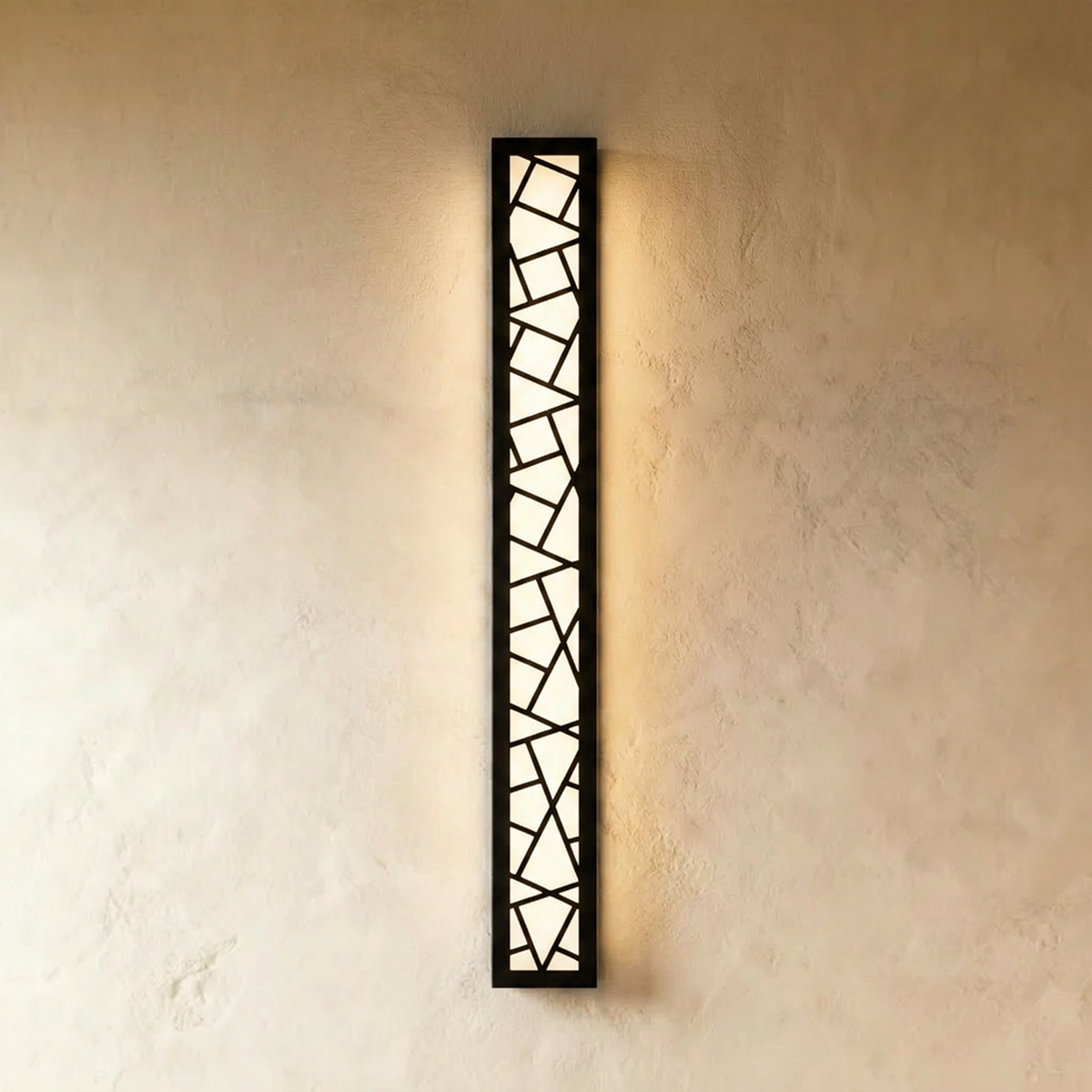 Clérachic the longest black wall lamp in the range, its cut-out geometric grille lit warm white on a plaster wall.