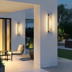 Clérachic wall lights on a white covered porch at dusk, with a lounge chair and side table on the terrace below.