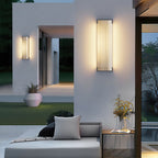 Clérachic wall lights on a white garden wall, with a daybed, cushions and a potted plant on the terrace below.