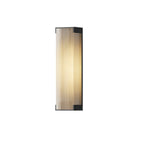 Side-angle view of a tall Clérachic wall light with a ribbed diffuser, lit softly on a white background.
