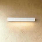 Clérachic longest slim white wall light in this set, washing a warm band of light down a limewashed wall.