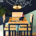 Clérachic oval blown glass pendant light in amber glass warming a pine table in a casual café corner.