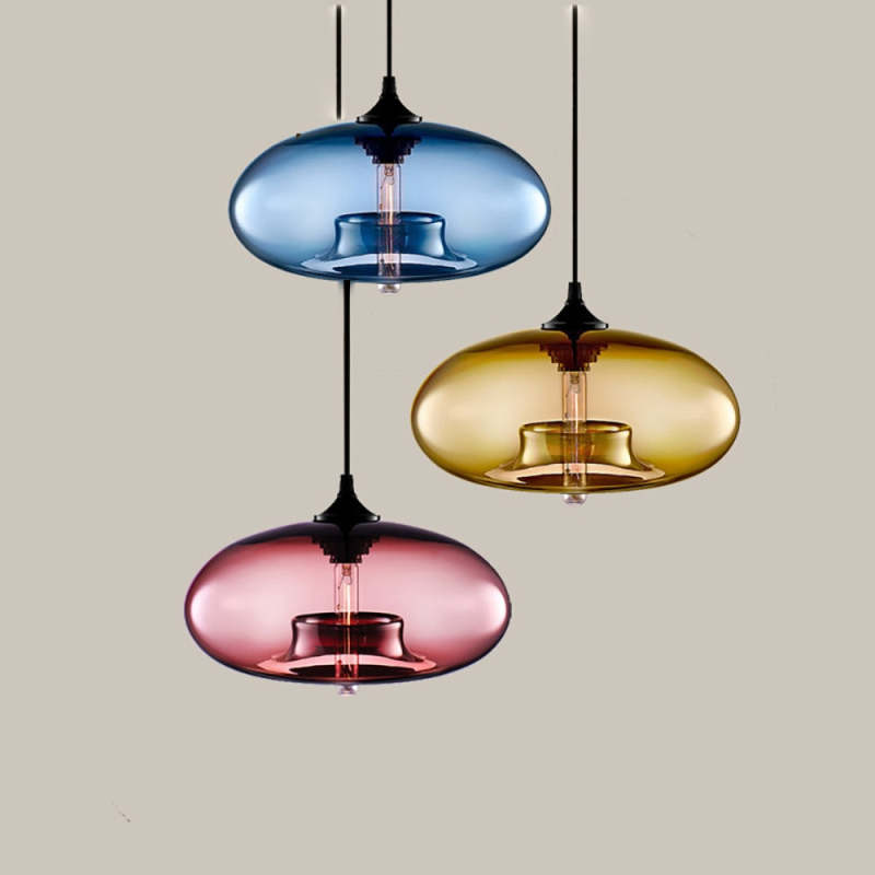 Blue, amber and pink Clérachic oval blown glass pendants hung at three heights against a warm taupe backdrop.