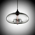 Studio shot of the Clérachic oval pendant light in clear glass, the bulb appearing to float on its ring of glass.