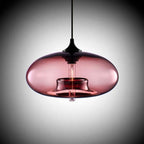Clérachic oval blown glass pendant light in dusty rose glass, lit filament reflected across the polished shade.