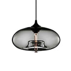 Clérachic oval blown glass pendant light in gray glass against plain white, warm filament bulb visible inside.