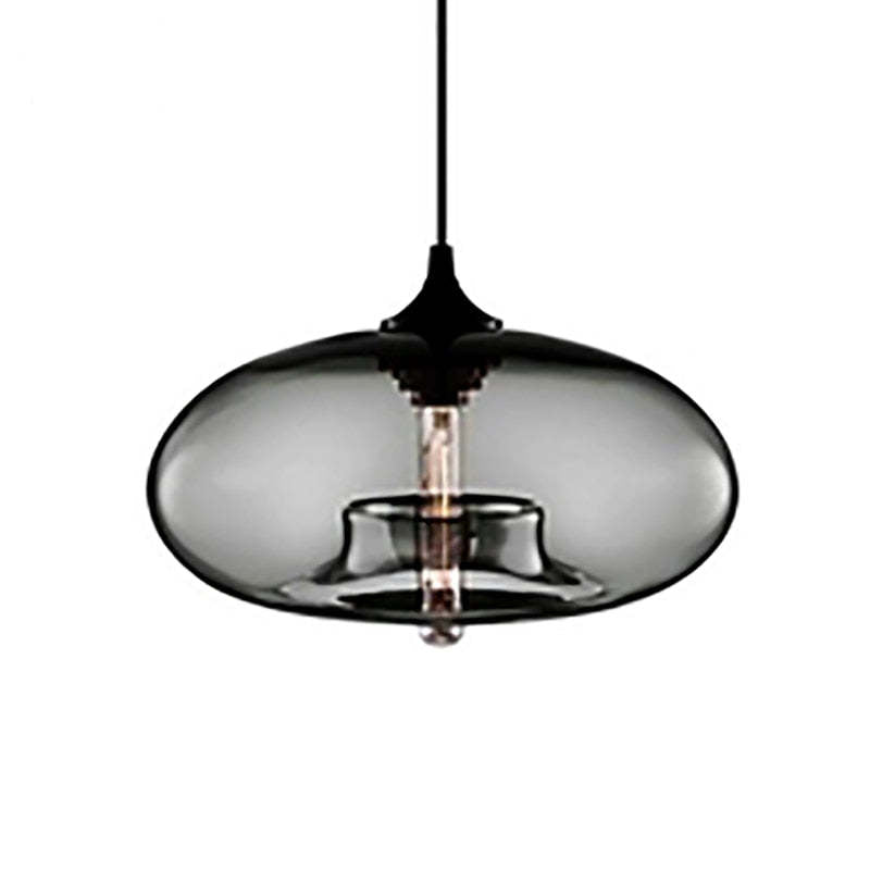 Clérachic oval blown glass pendant light in gray glass against plain white, warm filament bulb visible inside.