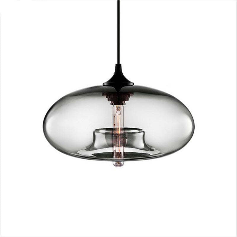 Clérachic oval blown glass pendant light in clear glass on a white background, socket collar and bulb fully visible.