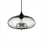 Clérachic oval blown glass pendant light in clear glass on a white background, socket collar and bulb fully visible.