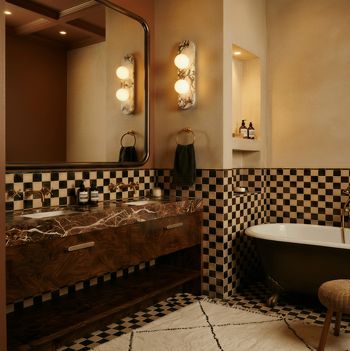 Clérachic pair of two-globe marble wall lights beside a large mirror, a marble-top basin unit and chequered tiles.