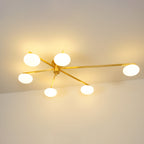 Clérachic Oval Opal Glass Ceiling Light lit in brass, six creamy ovals spreading a broad warm glow over a bare wall.