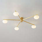 Five-arm brass Clérachic Oval Opal Glass Ceiling Light seen unlit, each oval shade chalk-white against grey plaster.