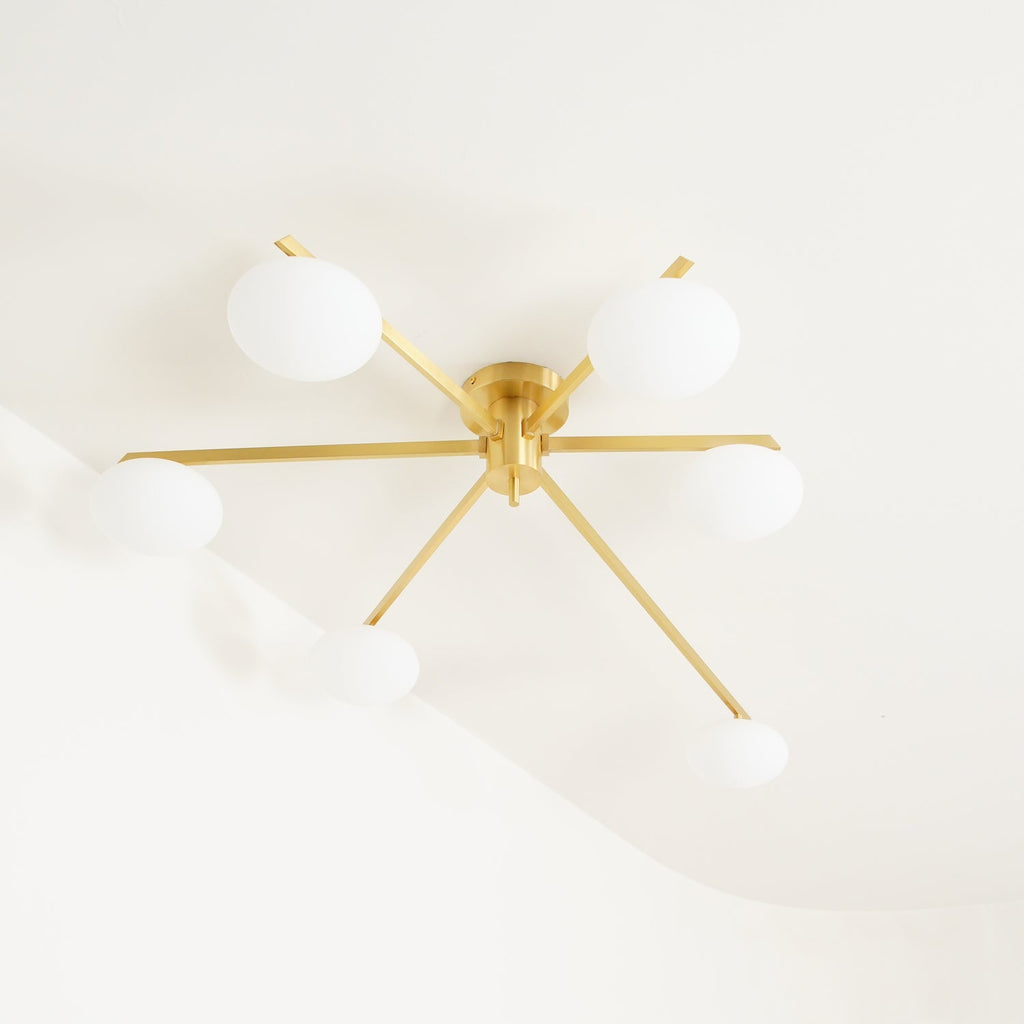 Clérachic Oval Opal Glass Ceiling Light in brass on a cream ceiling, its blade arms throwing a soft angled shadow.