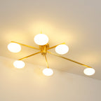 Warm-lit Clérachic Oval Opal Glass Ceiling Light in brass, the opal ovals glowing ivory against a golden ceiling wash.