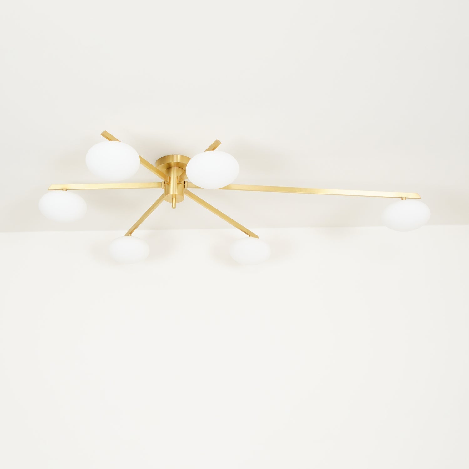 Clérachic Oval Opal Glass Ceiling Light in brass photographed head-on, six ovals sitting low beneath flat blades.