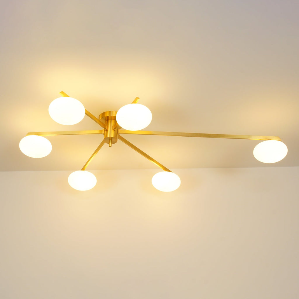 Clérachic Oval Opal Glass Ceiling Light switched on in brass, six shades lighting a room from the ceiling line.
