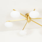 Close view of the Clérachic Oval Opal Glass Ceiling Light in brass, showing the grain on each blade arm and shade.