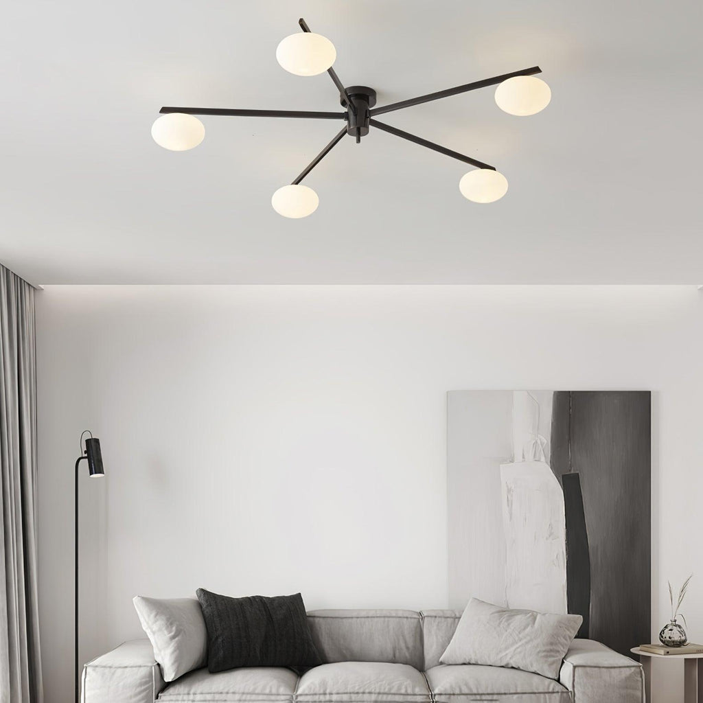 Clérachic Oval Opal Glass Ceiling Light in black above a grey sofa and floor lamp in a calm living room.