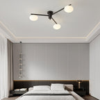 Clérachic Oval Opal Glass Ceiling Light in black above a bed, set against a panelled grey wall and coved ceiling.