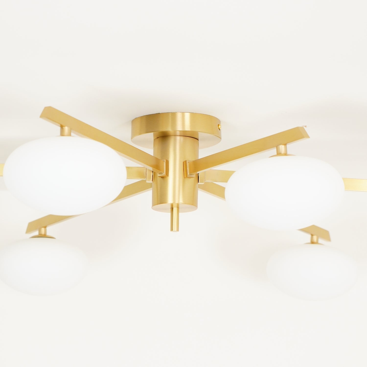 Underside detail of the Clérachic Oval Opal Glass Ceiling Light in brass, blade arms bolted to a round canopy.