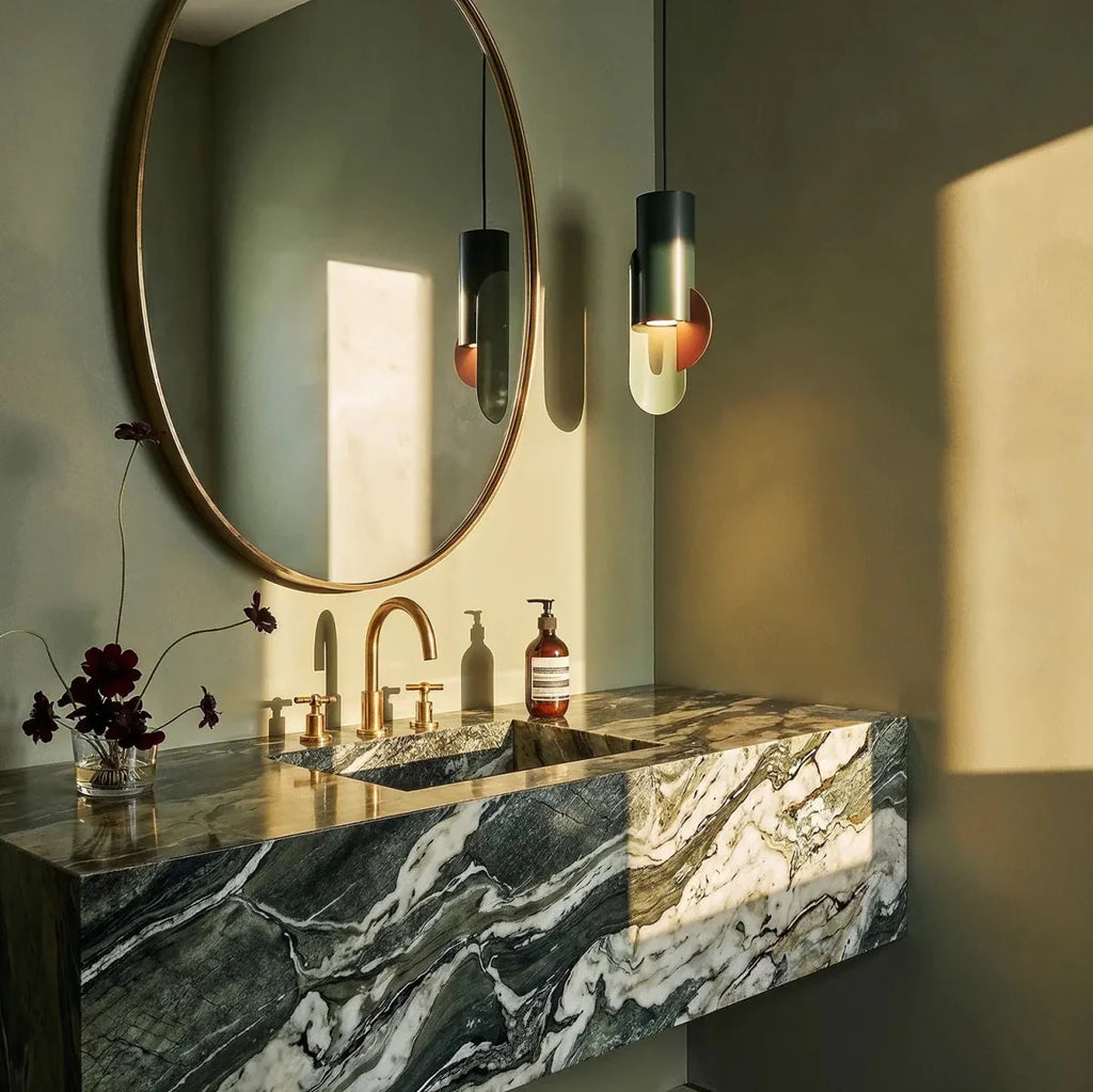 Clérachic teal pendant with a sage plate and terracotta disc beside a round mirror and a green marble washstand.