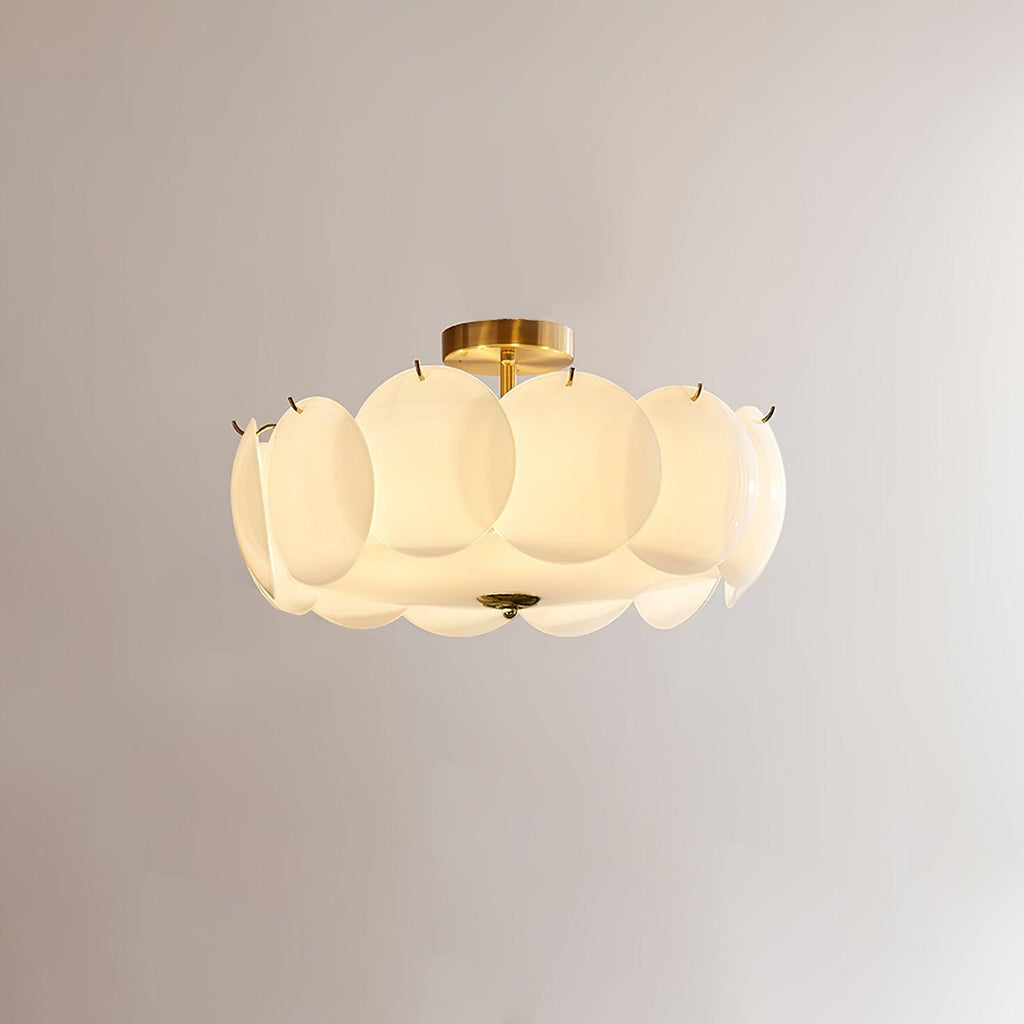 The Clérachic overlapping glass disc semi-flush ceiling light lit, its brass stem and glass discs glowing warmly.