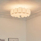 The Clérachic overlapping glass disc semi-flush ceiling light lit in a corner with ornate crown molding and a framed poster.