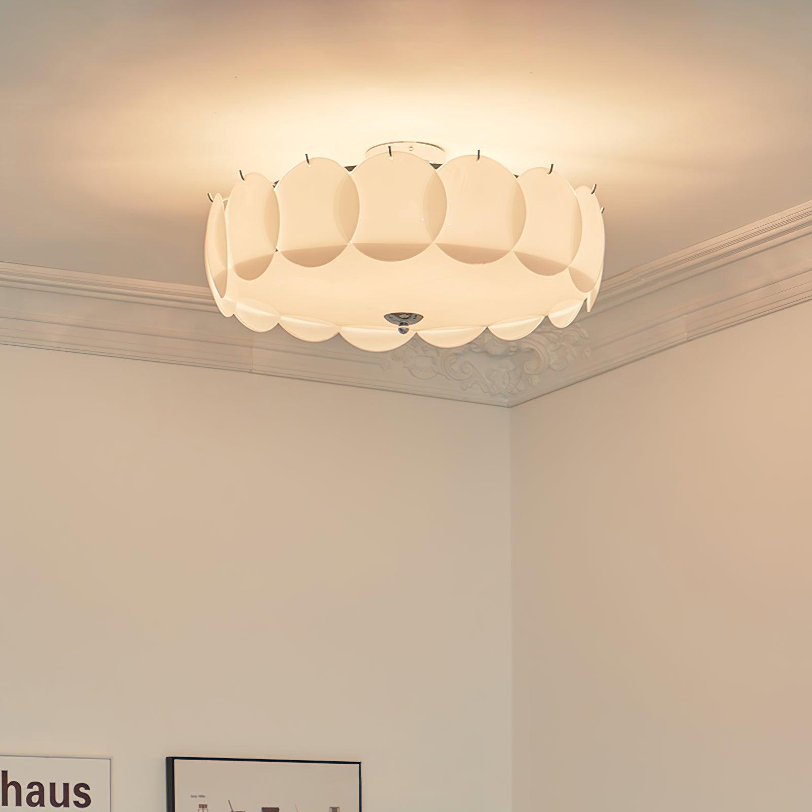The Clérachic overlapping glass disc semi-flush ceiling light lit in a corner with ornate crown molding and a framed poster.