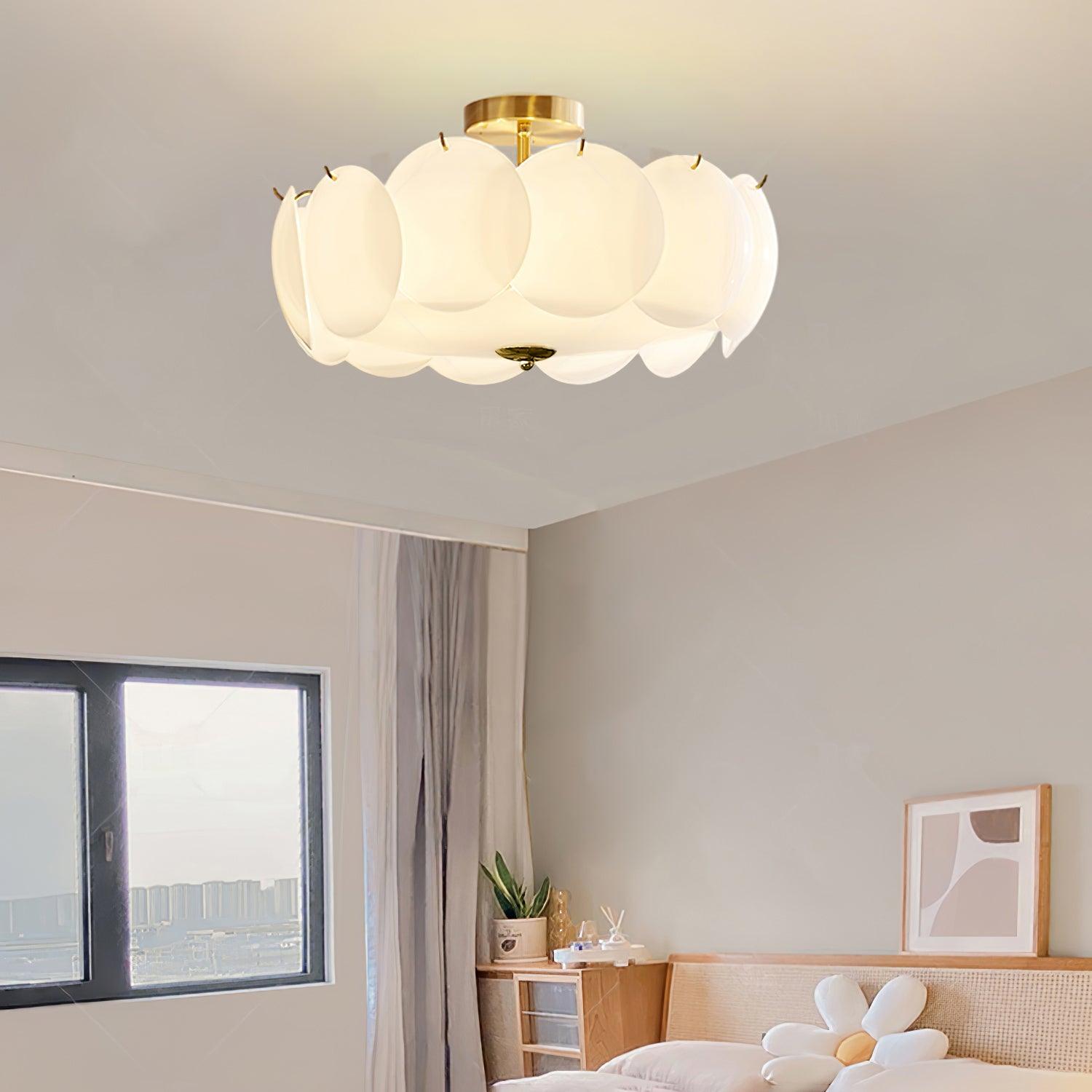 The Clérachic overlapping glass disc semi-flush ceiling light lit above a corner with framed art prints and crown molding.